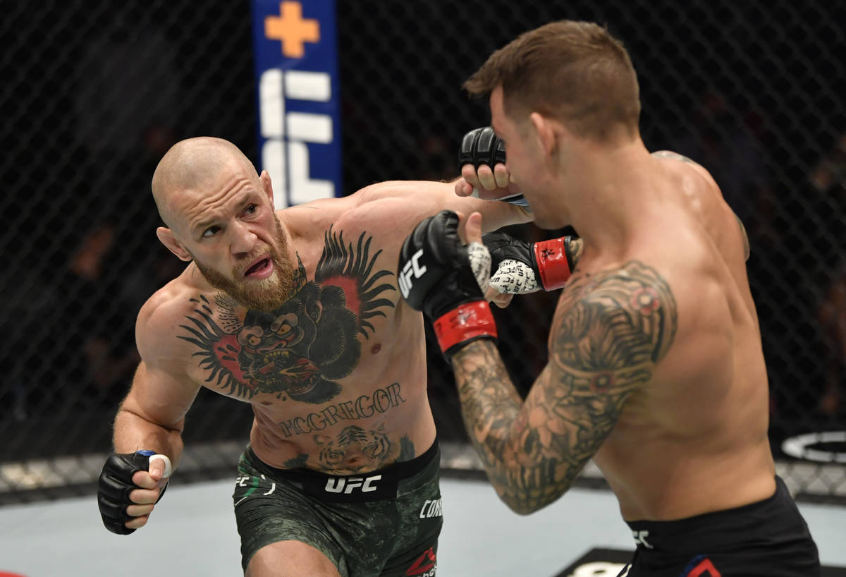 Conor McGregor of Ireland punches Dustin Poirier in a lightweight fight during the UFC 257 even ...