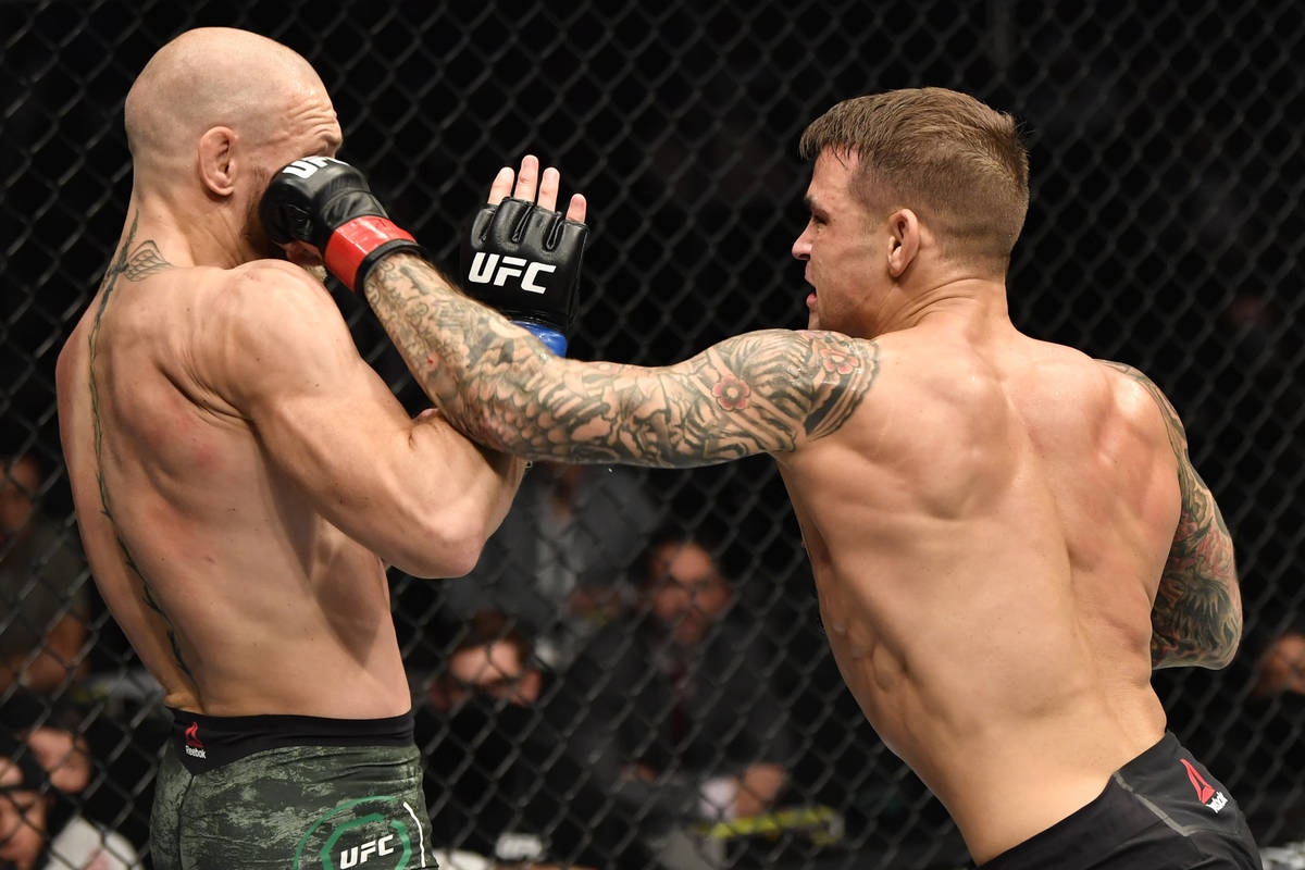 Dustin Poirier punches Conor McGregor of Ireland in a lightweight fight during the UFC 257 even ...