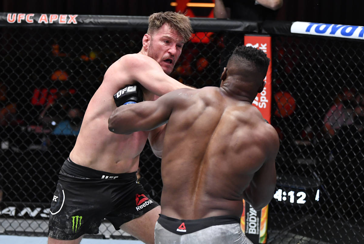 Stipe Miocic punches Francis Ngannou of Cameroon in their UFC heavyweight championship fight du ...