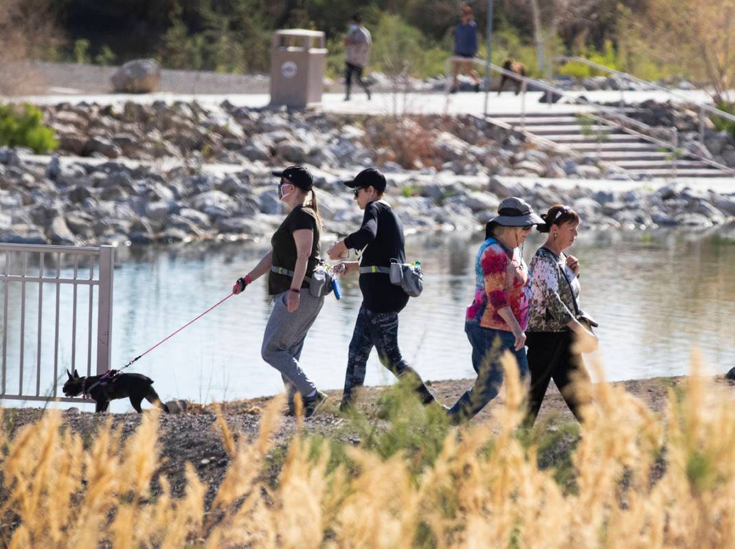 People walk at Cornerstone Park, on Monday, March 29, 2021, in Henderson. Winds up to 20 mph an ...