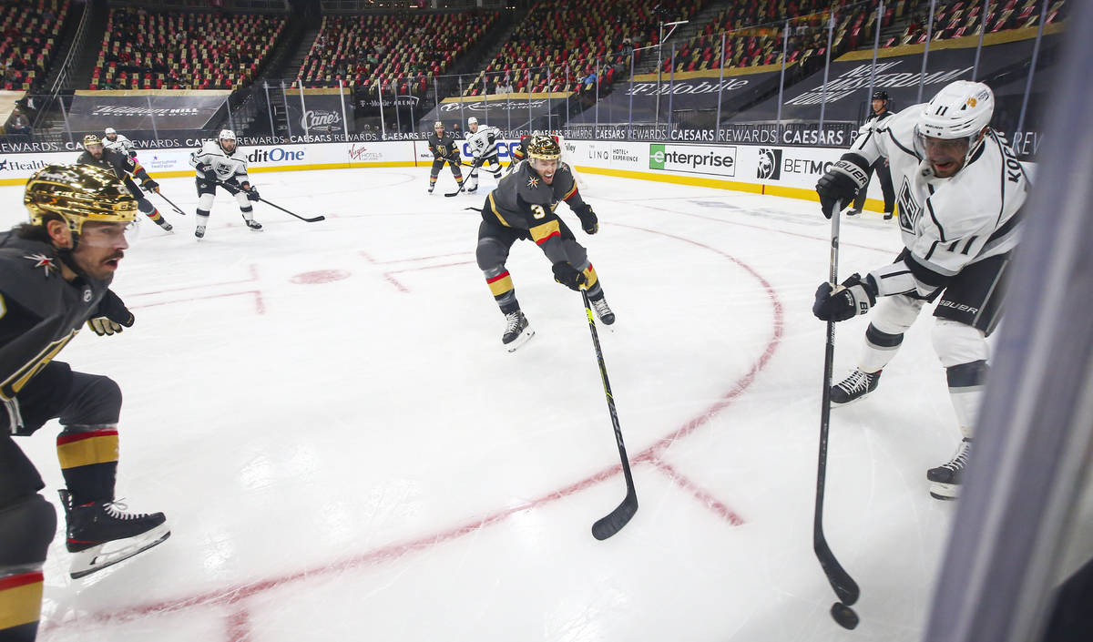 Los Angeles Kings' Anze Kopitar (11) passes the puck under pressure from Golden Knights' Brayde ...