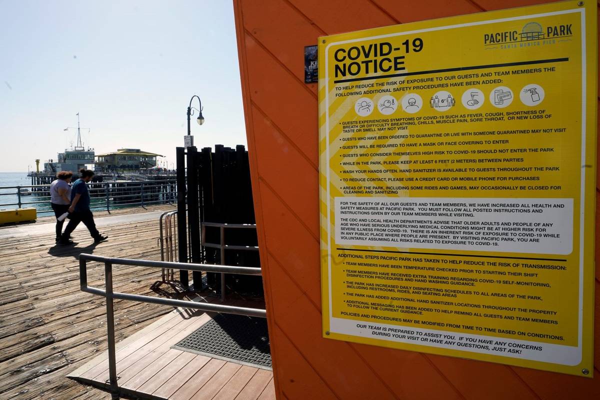 A COVID-19 notice is posted on the closed Pacific Park in the Santa Monica Pier in Santa Monica ...