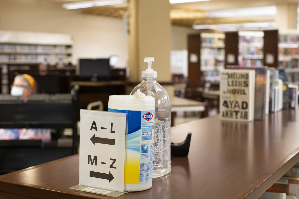 Hand sanitizer and antibacterial wipes are available for use as workers keep the library runnin ...