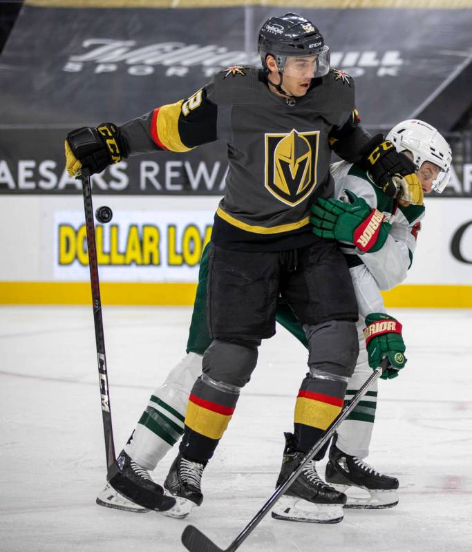 Golden Knights left wing Tomas Nosek (92) battles for the puck with Minnesota Wild defenseman I ...