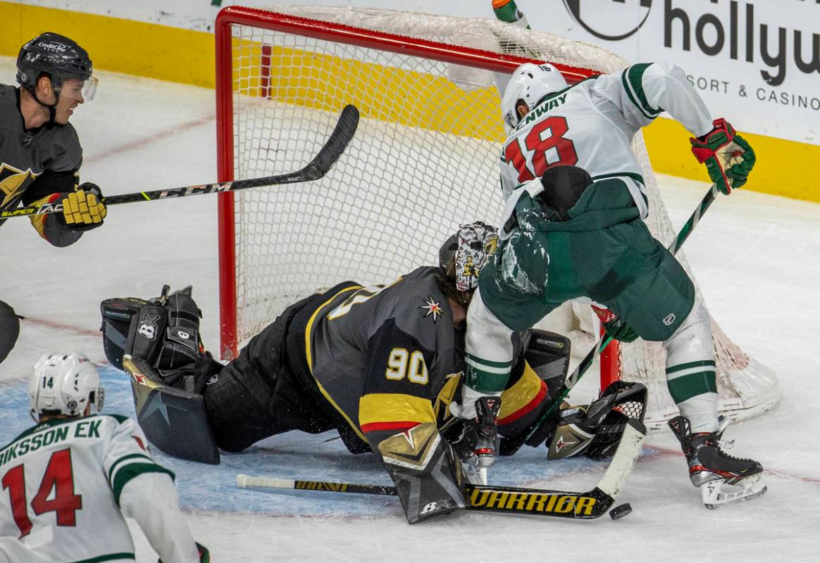 Golden Knights goaltender Robin Lehner (90) crashes into the knee of Minnesota Wild left wing J ...