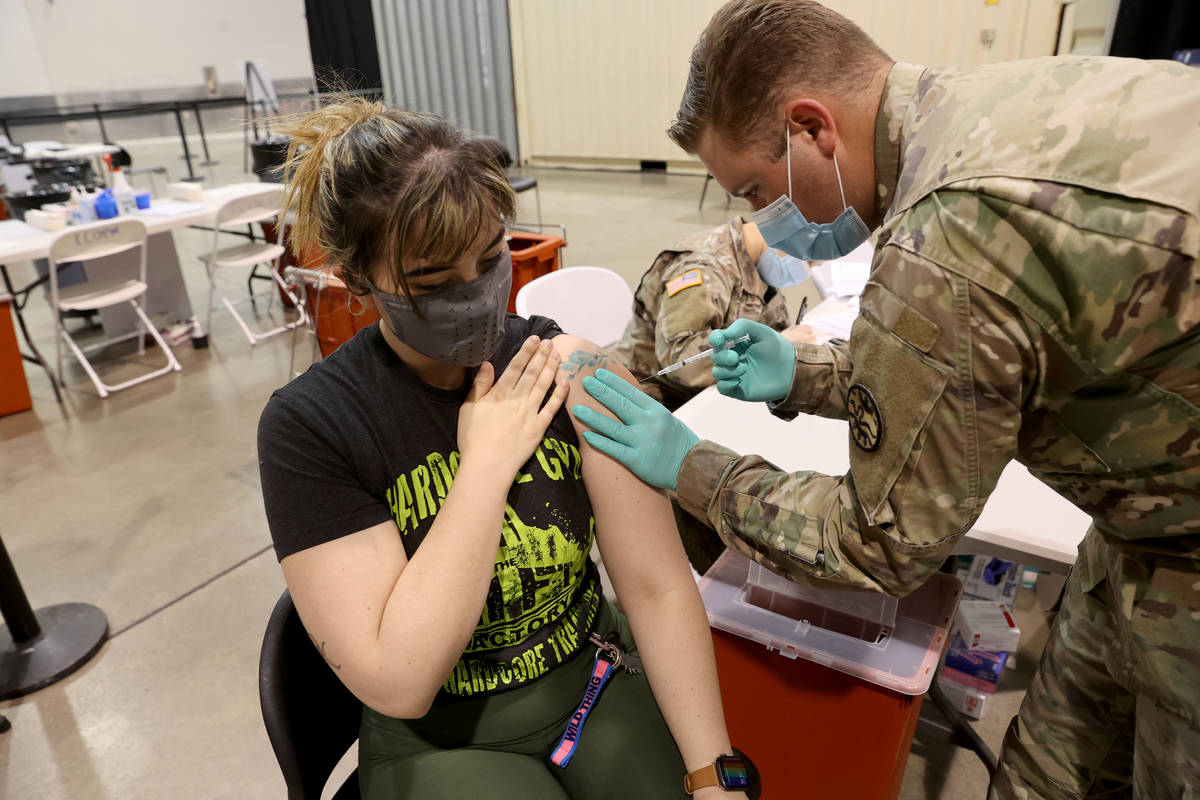 Micah Haji-Sheikh, 27, of North Las Vegas receives the COVID-19 vaccine from Nevada National Gu ...