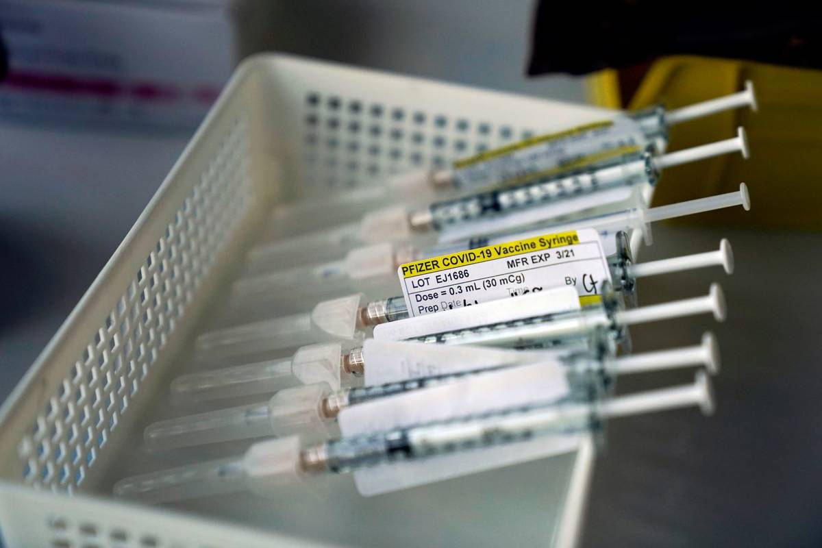 Syringes containing the Pfizer-BioNTech COVID-19 vaccine sit in a tray in a vaccination room at ...