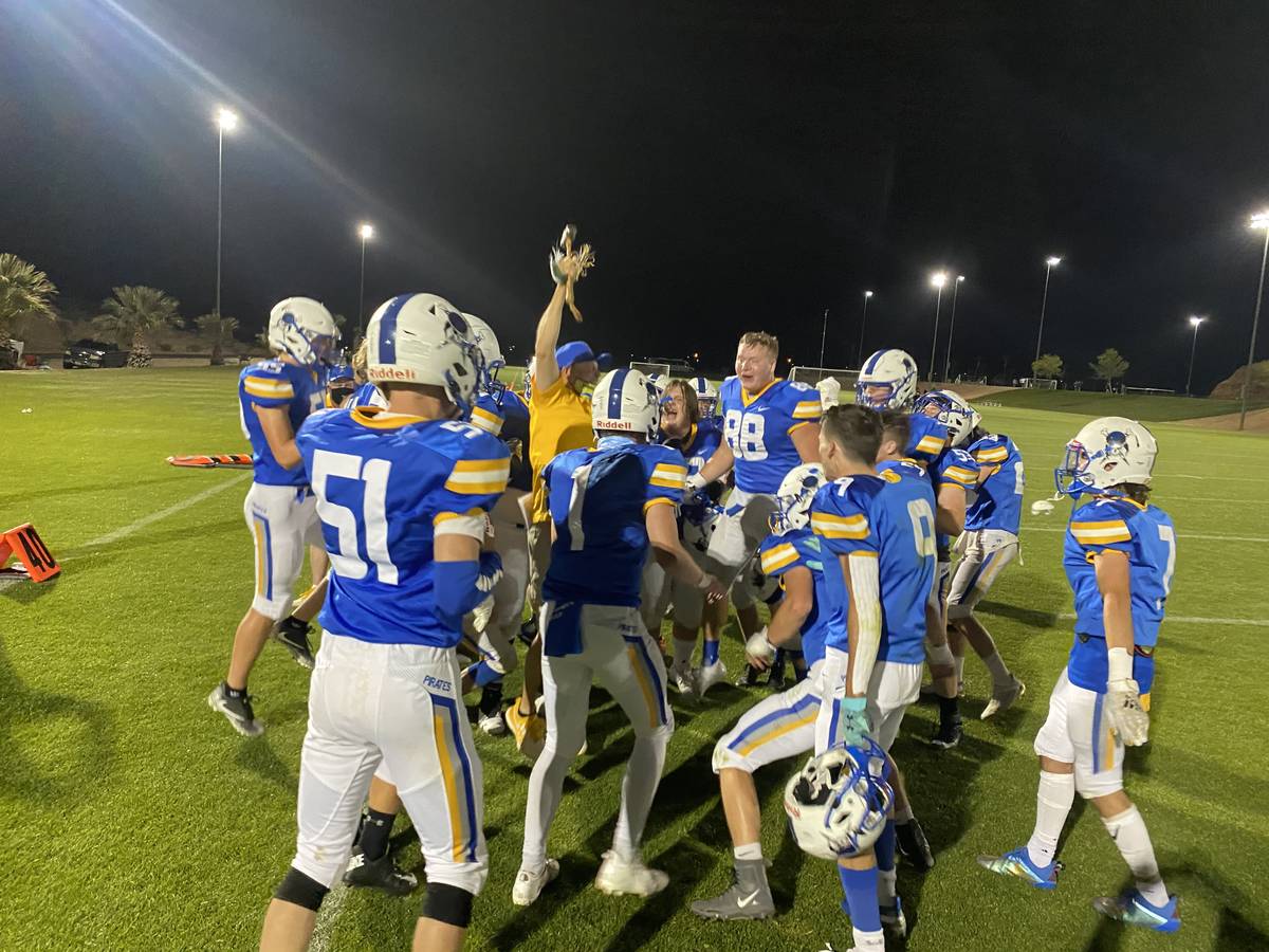 Moapa Valley coach Brent Lewis celebrates with the hammer as players circle around after the Pi ...