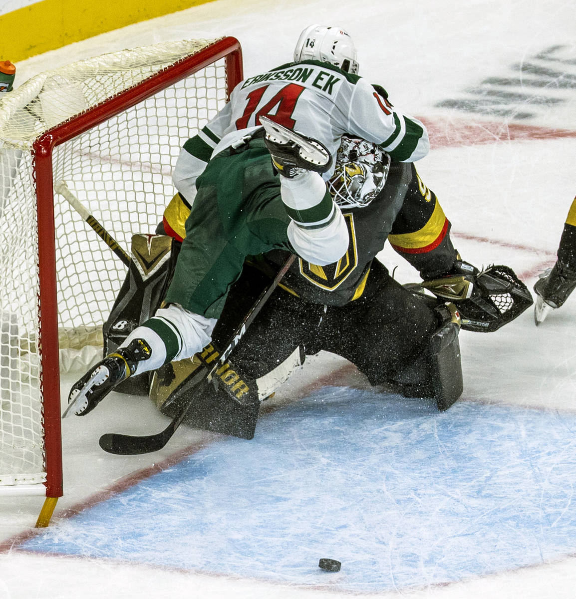 Minnesota Wild center Joel Eriksson Ek (14) crashes into Golden Knights goaltender Robin Lehner ...