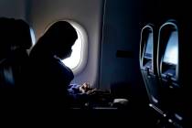 In a Wednesday, Feb. 3, 2021, file photo, a passenger wears a face mask during an airline fligh ...