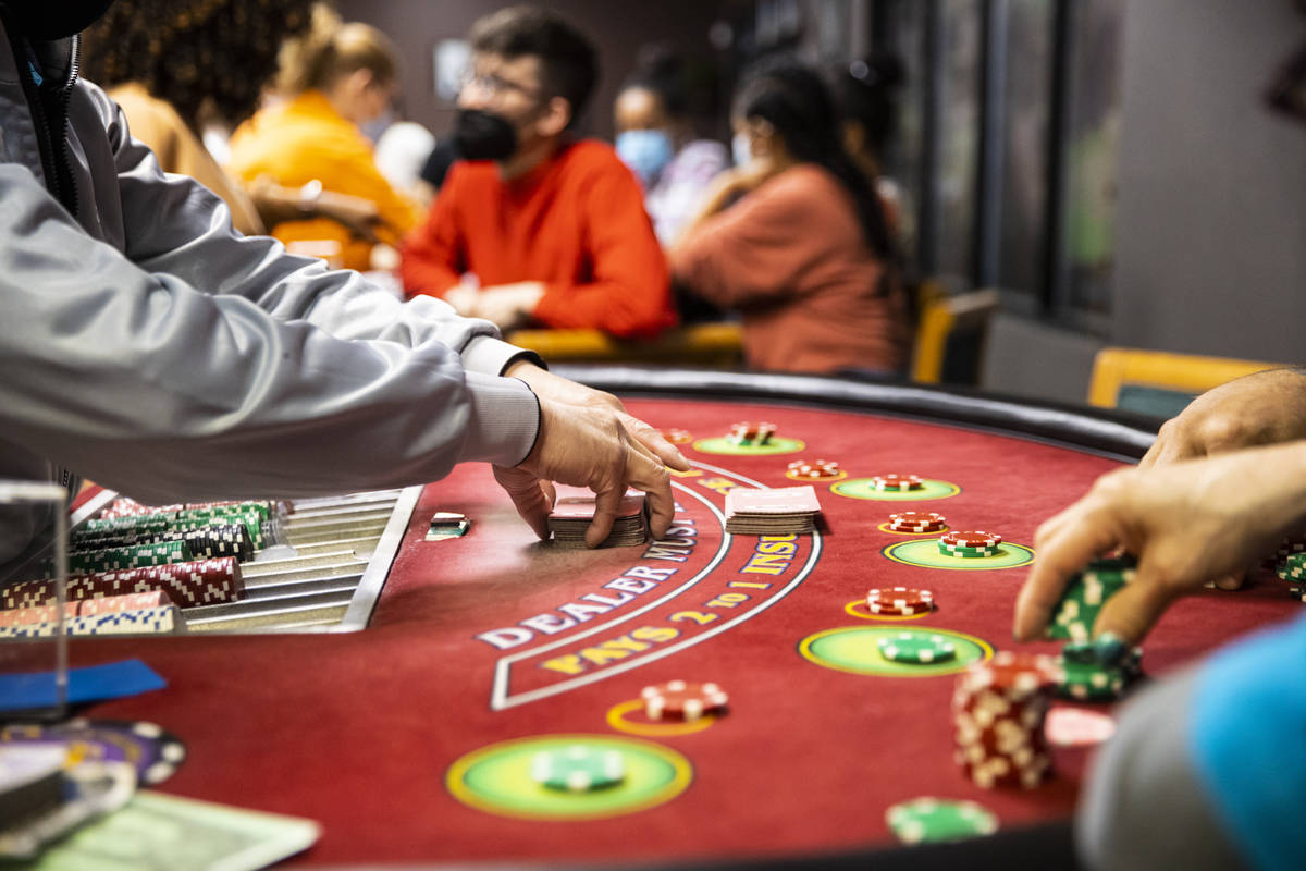 Student Chuong Van shuffles cards while working a blackjack table during class at the Crescent ...