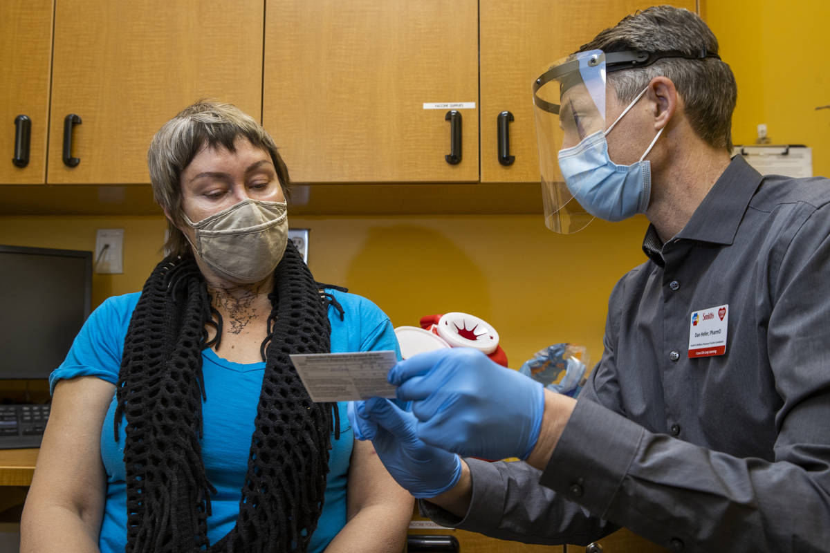 Customer Lee Lahann, left, is instructed following her first Moderna COVID-19 vaccine from Dan ...