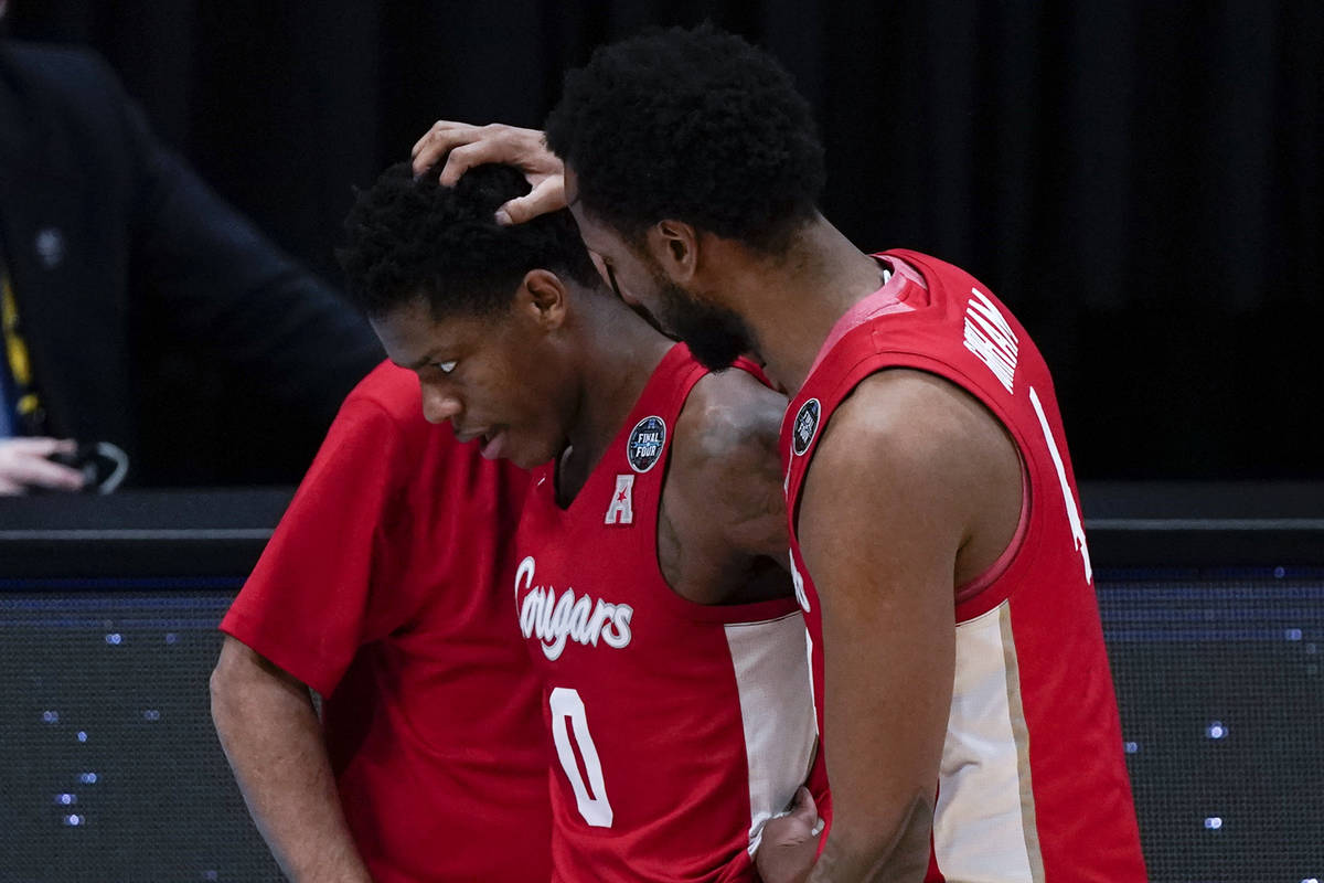 Houston guard Marcus Sasser (0) walks off the court with teammate forward Justin Gorham, right, ...