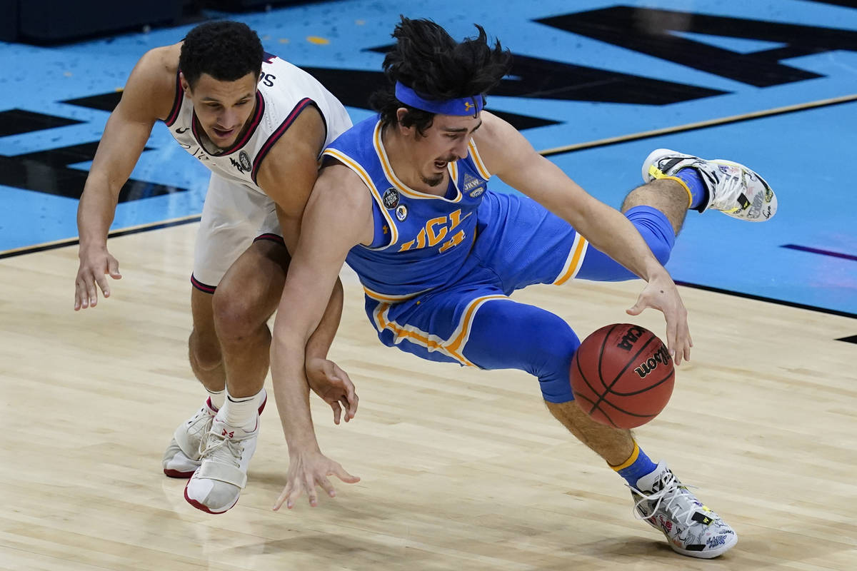 UCLA guard Jaime Jaquez Jr. fights for a loose ball with Gonzaga guard Jalen Suggs, left, durin ...