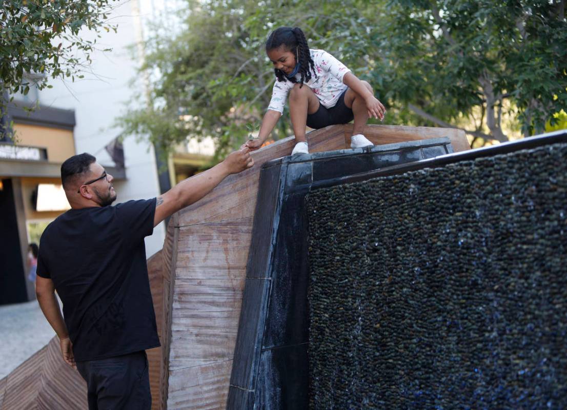 Maia Olivas, 6, of Houston, Texas cools off near the water walls with her father Juan at The Pa ...