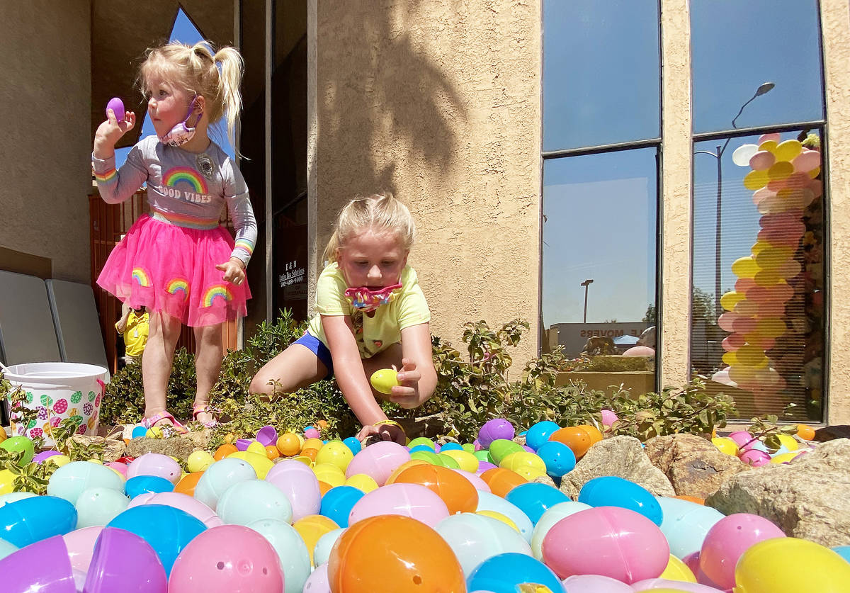 Amelia Legate, left, 3, and sister Eleanor, 6, hunt for Easter Eggs during an Easter egg hunt a ...