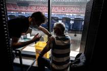 Patients receive an injection of the Moderna Covid-19 vaccine on the opening day of a mass vacc ...