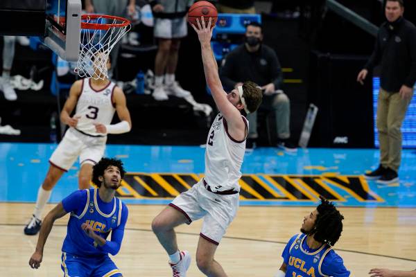 Gonzaga forward Drew Timme (2) dunks the ball over UCLA guard Johnny Juzang, left, and guard Ty ...