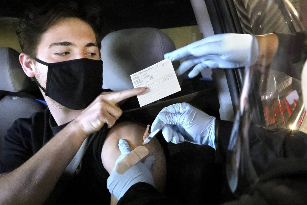 Tyler Rorah, 18, of Brooksville, receives a Moderna COVID 19 vaccine shot from LPN Sonie Woods, ...