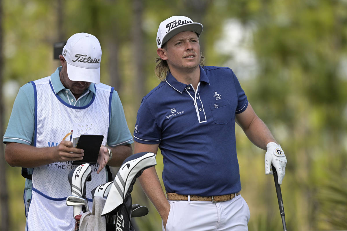 Cameron Smith, right, of Australia, waits to hit his tee shot on the second hole during the thi ...