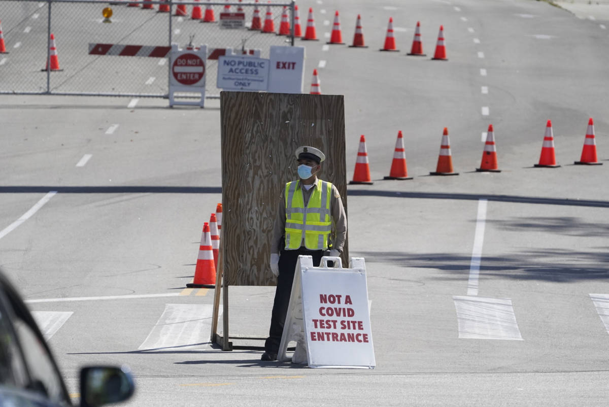 A Los Angeles Traffic control officer directs vehicles to an alternative entrance to the Dodger ...