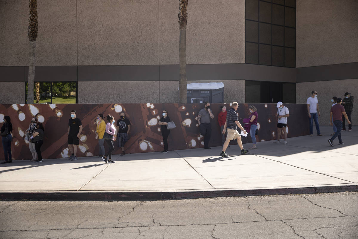 People wait in line to receive the COVID-19 vaccine at the Cashman Center in Las Vegas, April 6 ...