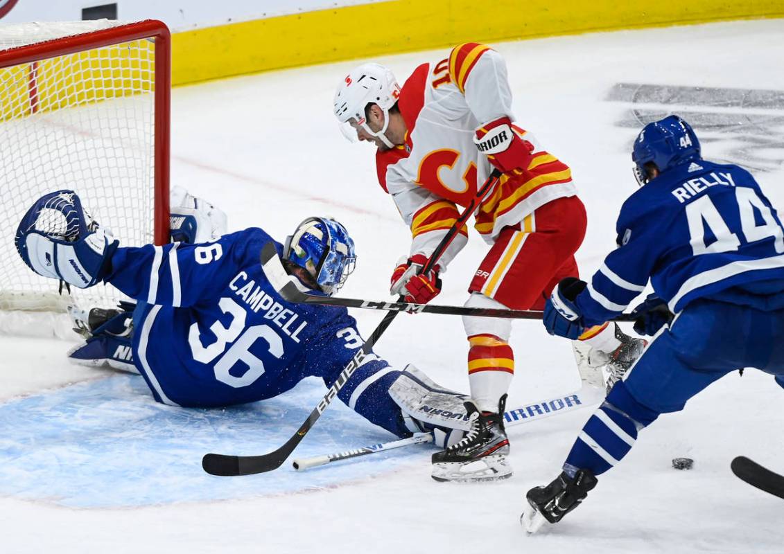 Toronto Maple Leafs goaltender Jack Campbell (36) poke-checks Calgary Flames forward Derek Ryan ...