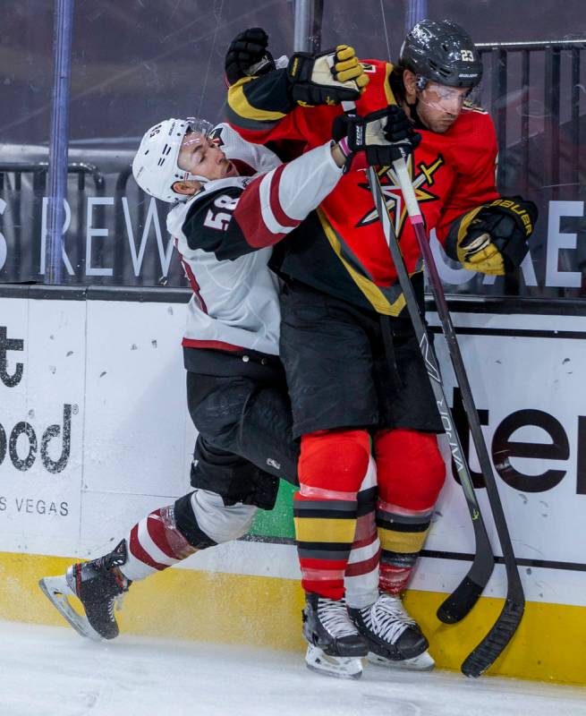 Arizona Coyotes left wing Michael Bunting (58) battles with Golden Knights defenseman Alec Mart ...