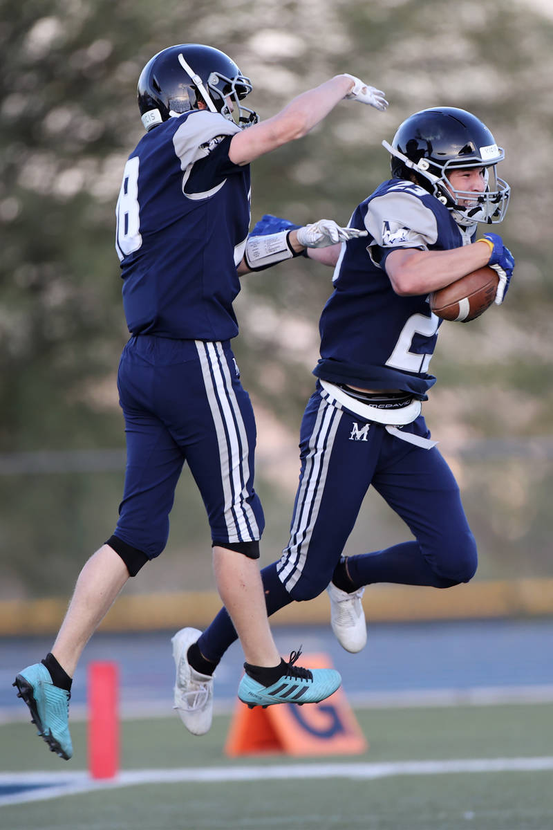 Meadows' Ryan Hannig (23), right, celebrates a touchdown with his teammate John McGill (18), in ...