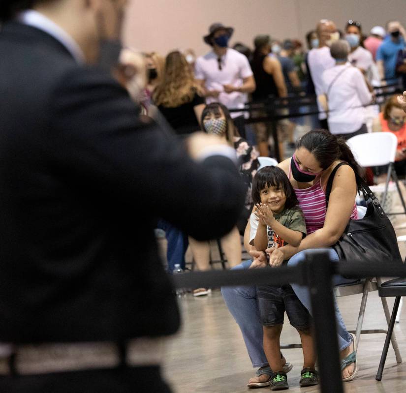 Elizabeth Montanez holds her son, Juan Mejia, 2, as he claps for Mariachi Nuestras Raices' perf ...