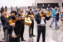 Mariachi Nuestras Raices performs to a room of people waiting in line for COVID-19 vaccines or ...