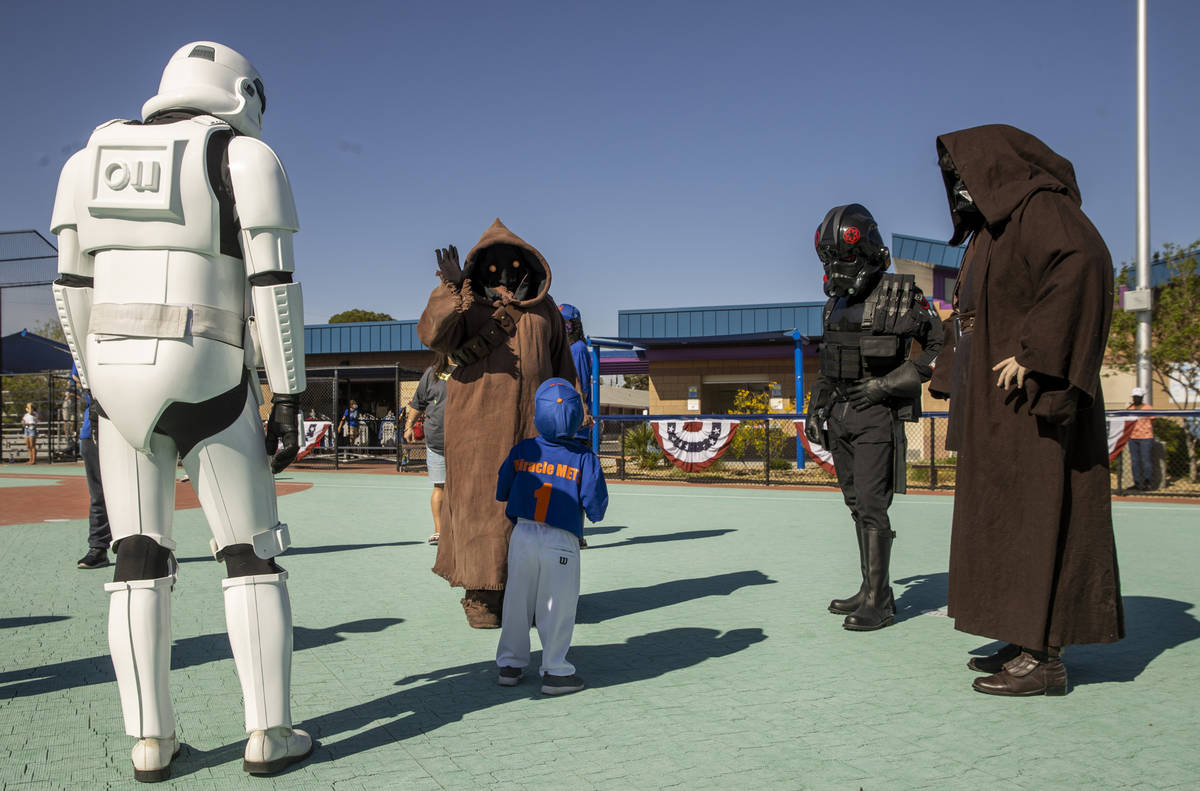 Player Ryzer ÒRyzÓ Watson, 3, greets Star Wars characters in the outfield during a Mi ...