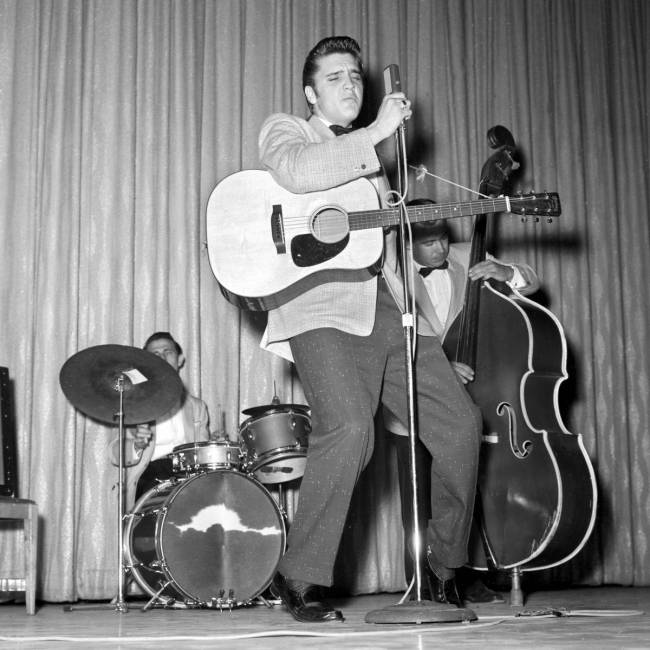 Elvis Presley performs, along with D.J. Fontana on drums and Bill Black on bass, in the New Fro ...