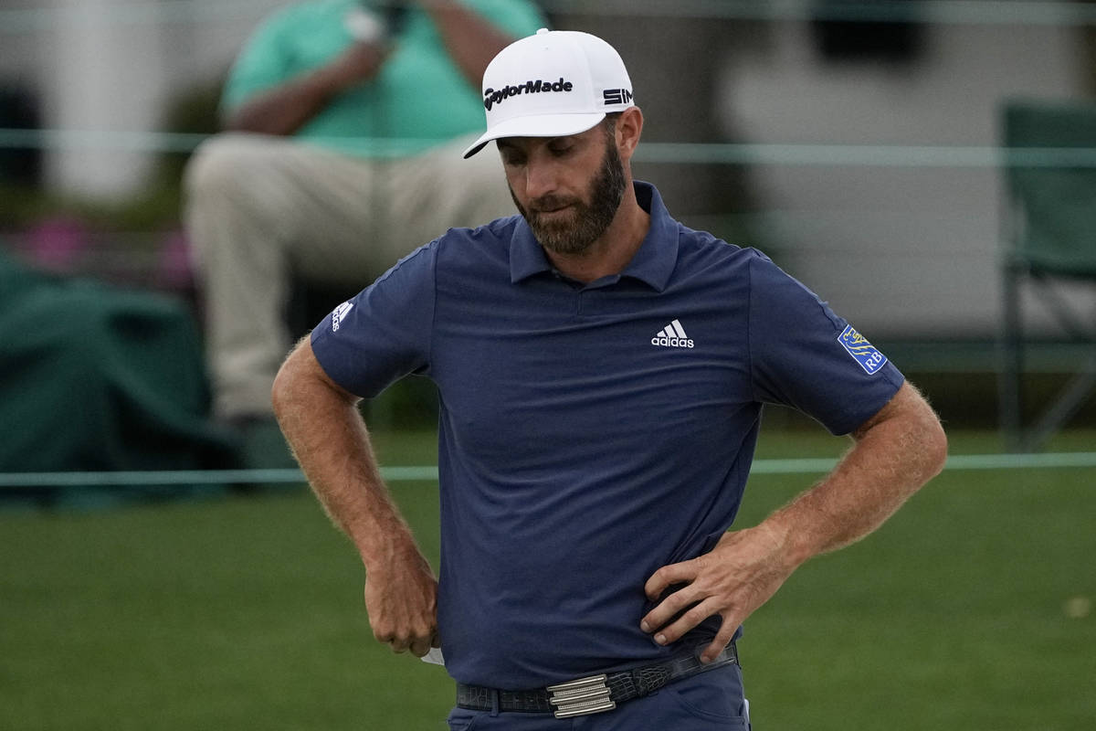 Dustin Johnson looks down after putting on the 18th hole during the second round of the Masters ...