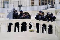 Police keep a watch on demonstrators who tried to break through a police barrier at the Capitol ...