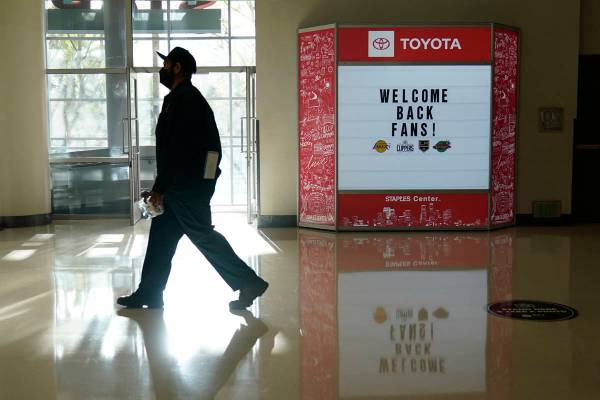 A man walks past a sign welcoming back fans before an NHL hockey game between the Vegas Golden ...