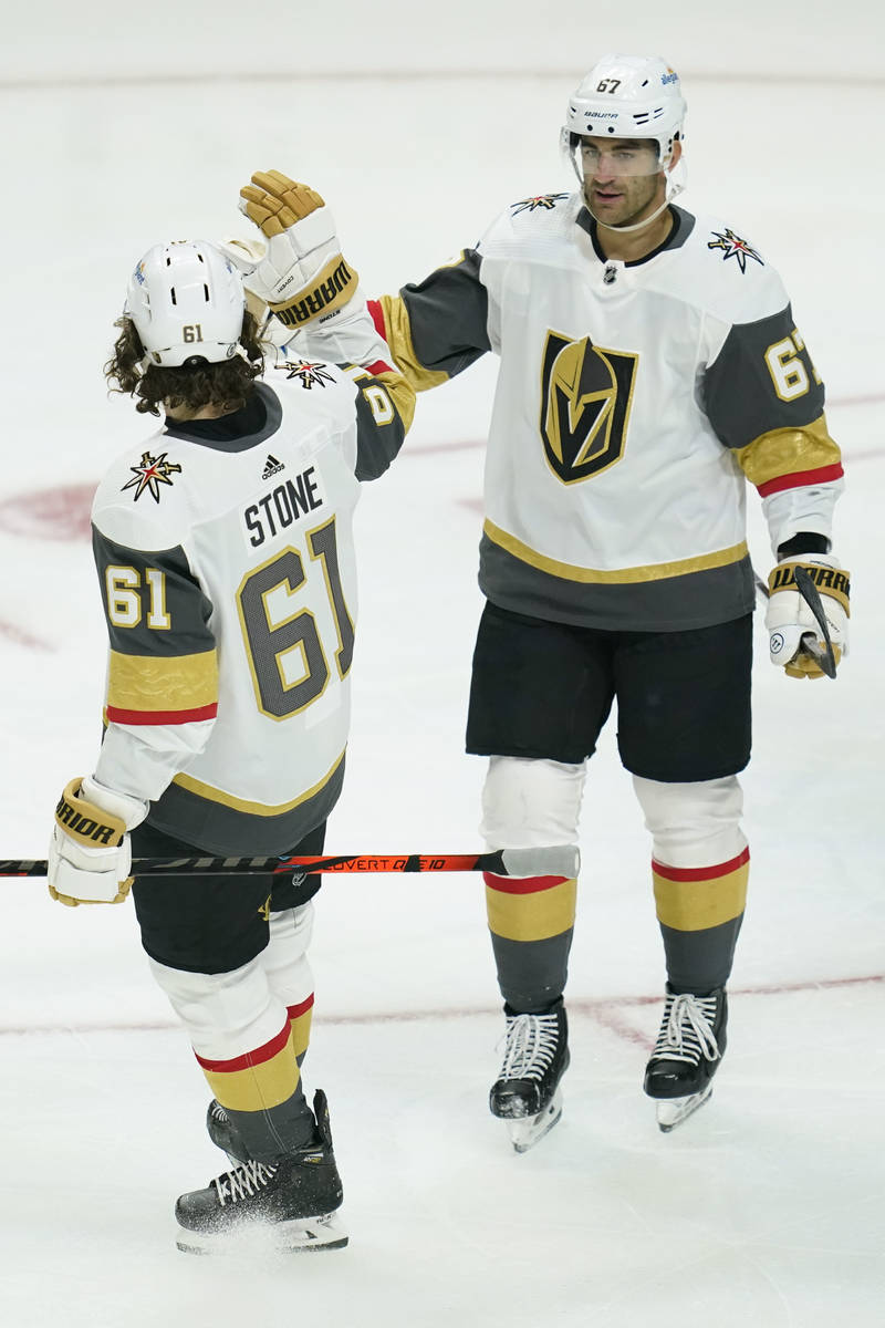 Vegas Golden Knights right wing Mark Stone (61) high-fives left wing Max Pacioretty (67) after ...