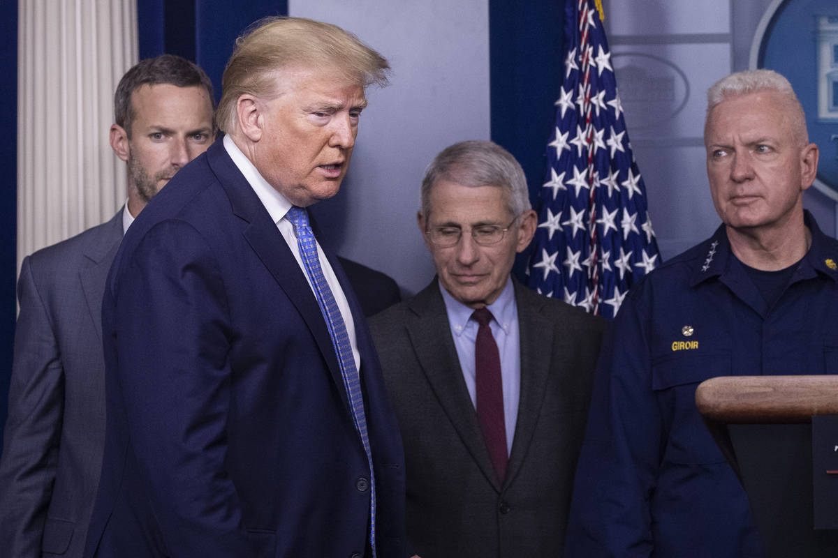 Then-President Donald Trump arrives to speak, with Dr. Anthony Fauci, director of the National ...