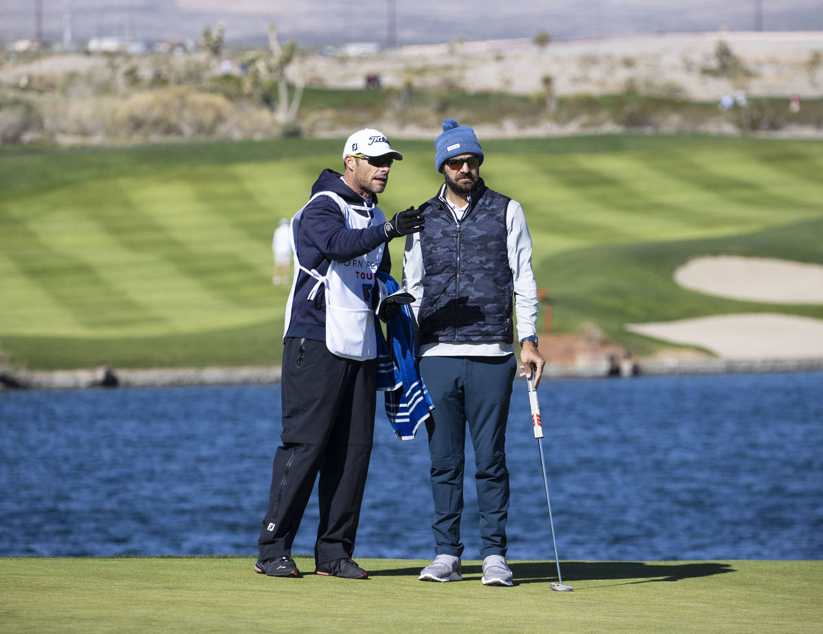 Chandler Blanchet of Jacksonville Beach, Fla., right, consults his golf caddy on fourth hole du ...