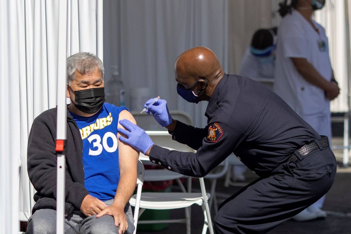 A man receives a COVID-19 vaccine shot at the Tiburcio Vasquez Health Center's vaccination site ...