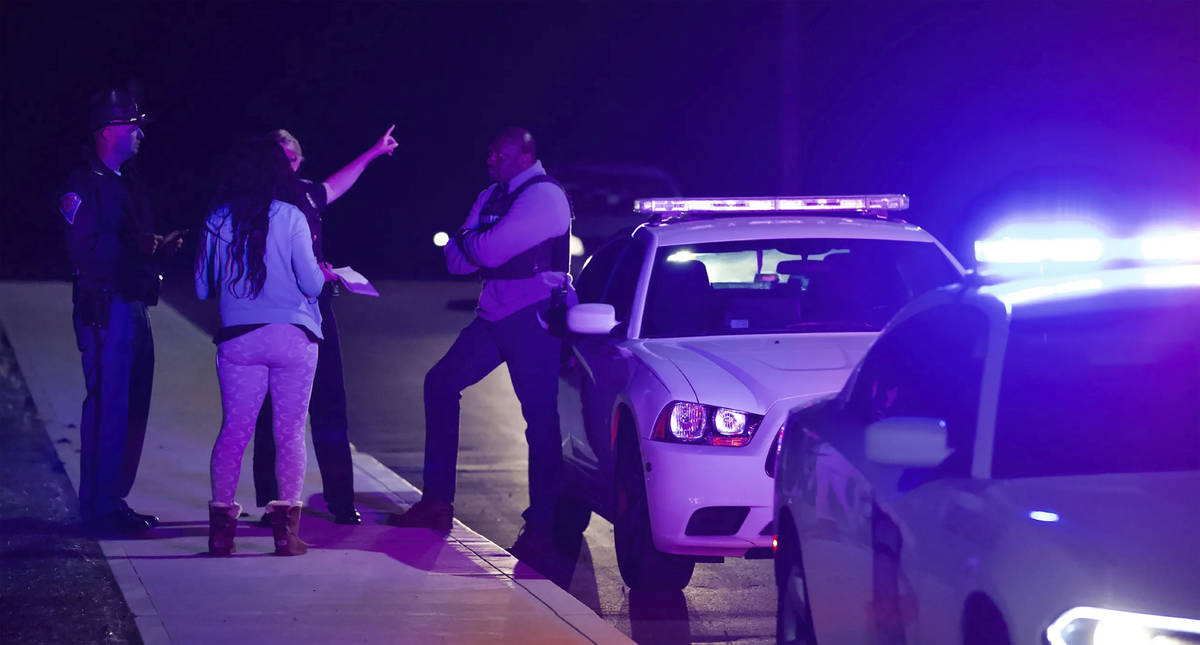 A woman asks law enforcement near the FedEx hub following a shooting in Indianapolis, IN., Frid ...