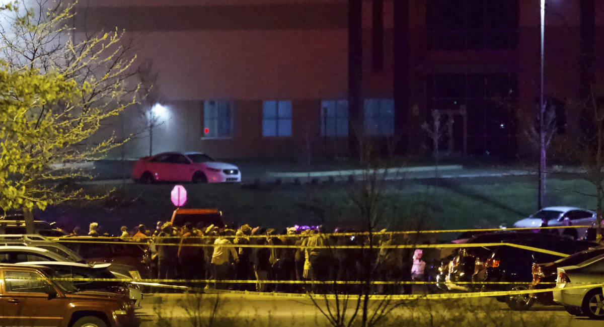 People stand outside a FedEx facility near Indianapolis International Airport after a shooting ...