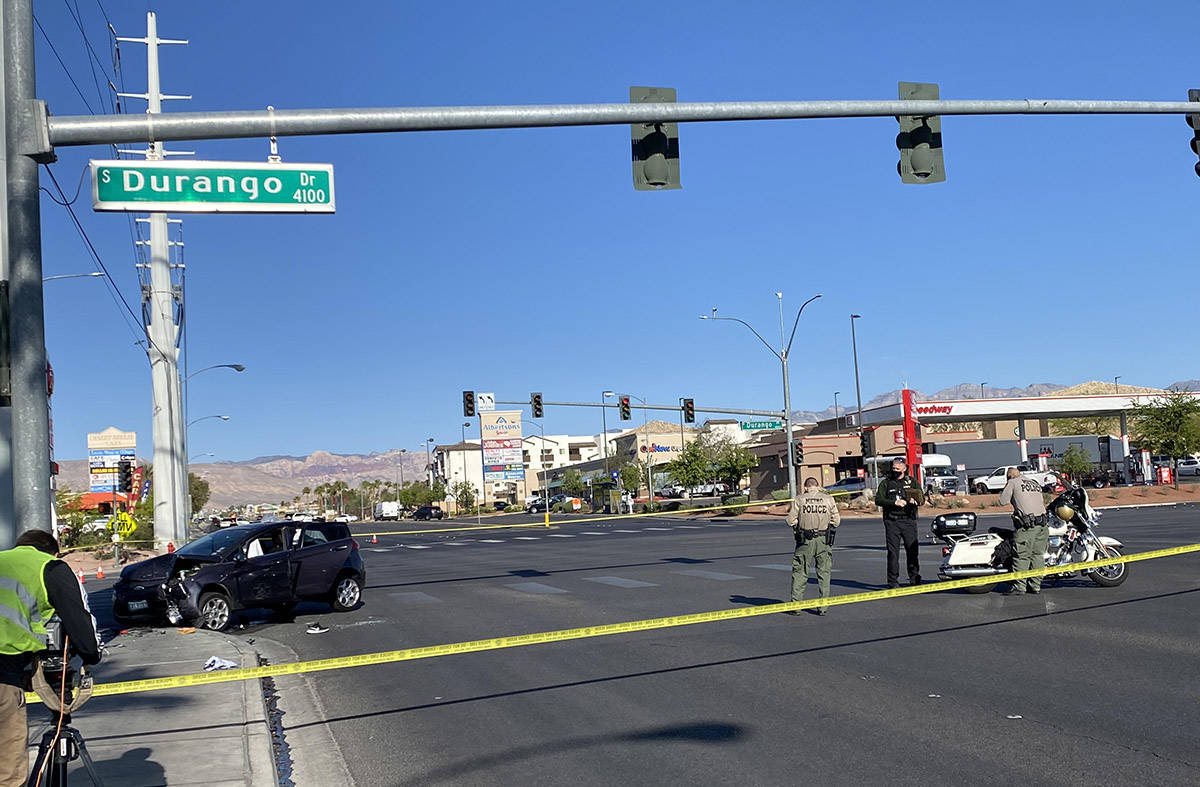 Las Vegas police officers at the scene of an SUV that crashed into a power line transmission po ...