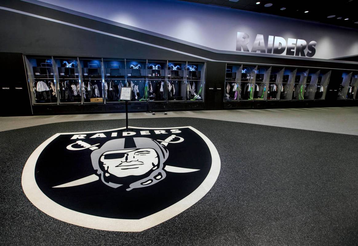 A large logo is painted on the floor in the expansive locker room within the Las Vegas Raiders ...