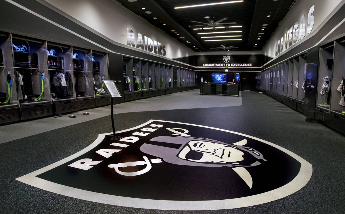 A large logo is painted on the floor in the expansive locker room within the Las Vegas Raiders ...