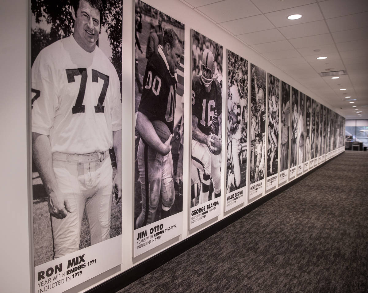 Football Hall of Fame players from the Oakland and Las Vegas Raiders line a hallway within the ...