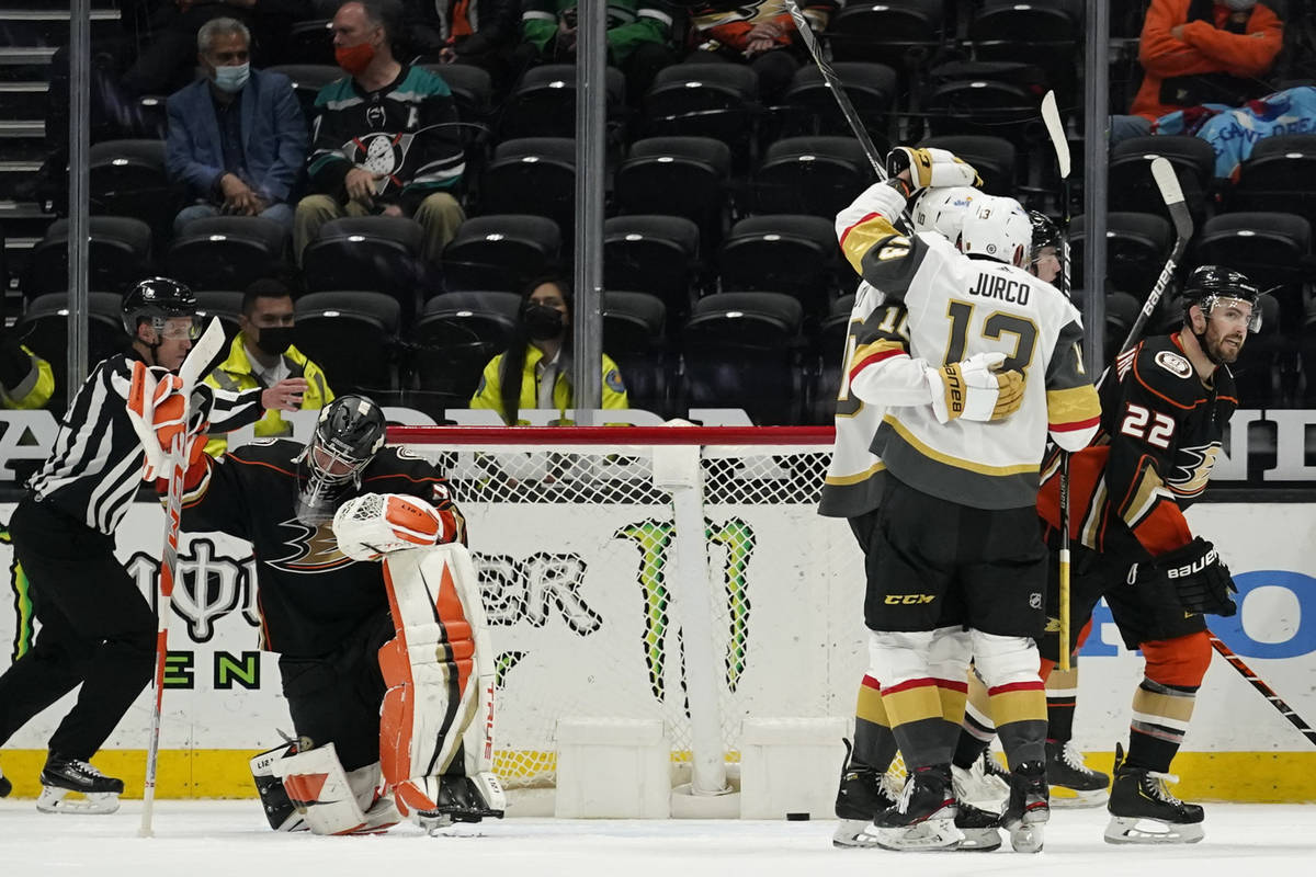 Vegas Golden Knights players celebrate and Anaheim Ducks goaltender John Gibson, left, kneels a ...