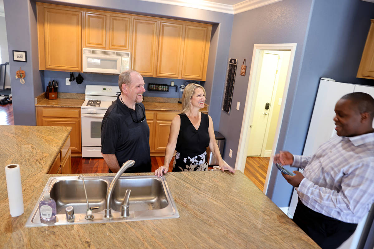 Realtor Shawn Cunningham, right, shows a Las Vegas house for sale to David Verno and Trudy Lope ...