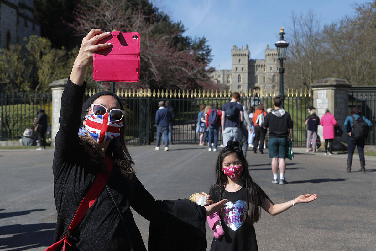 People take photographs outside the Windsor Castle in Windsor, England, following the funeral o ...
