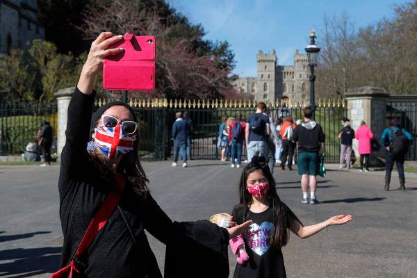 People take photographs outside the Windsor Castle in Windsor, England, following the funeral o ...